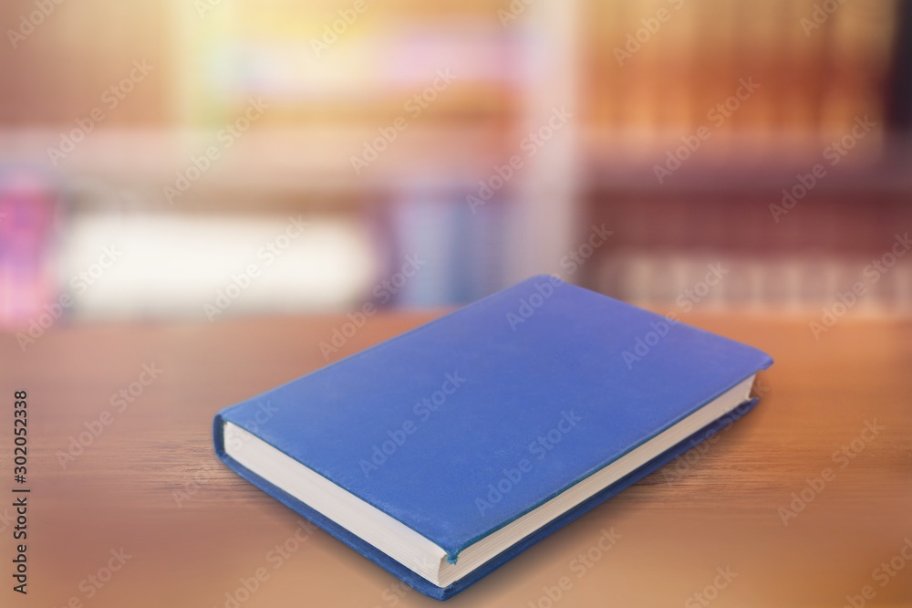 图书馆木桌上的一本蓝书