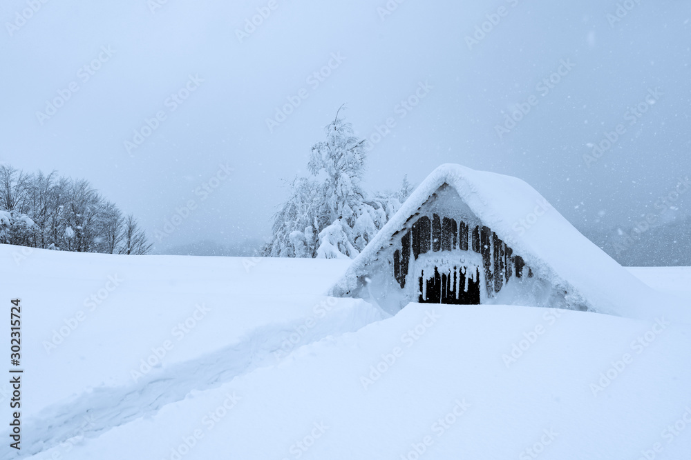 Fantastic winter landscape with wooden house in snowy mountains. Christmas holiday concept