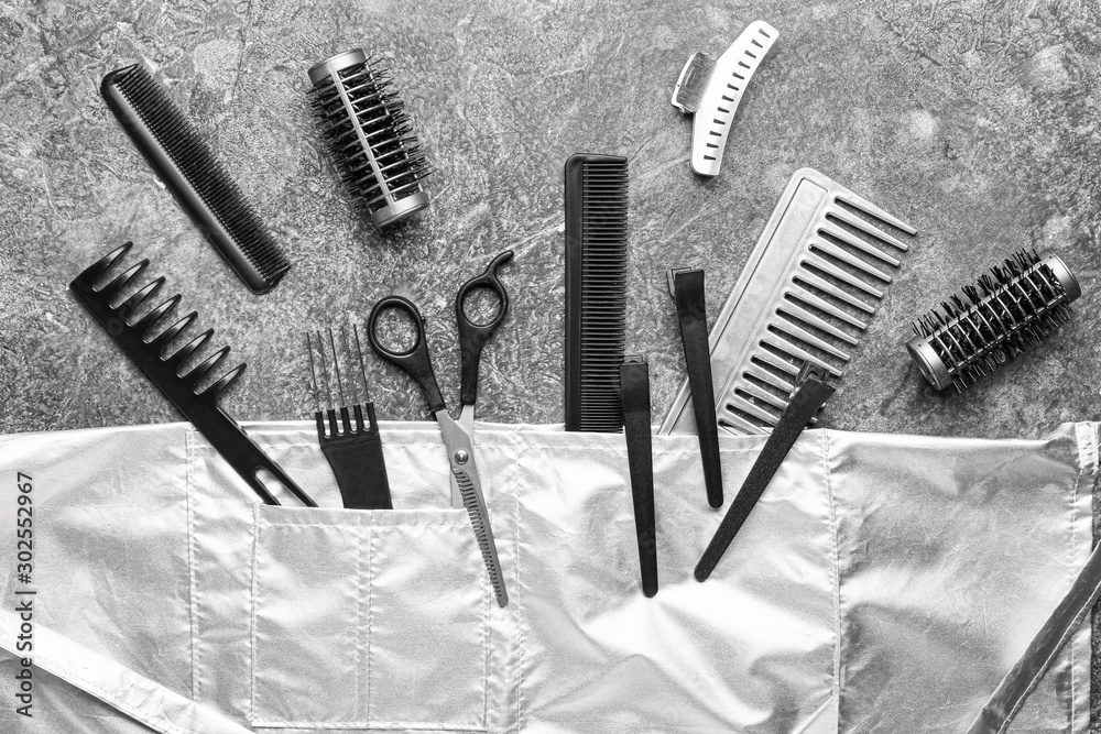 Set of hairdresser tools and accessories on grey background