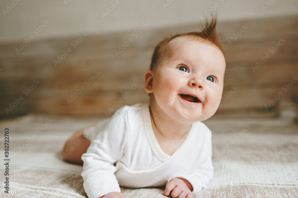 快乐的婴儿在床上爬行微笑可爱的孩子姜黄色头发的家庭生活方式3个月大的ki