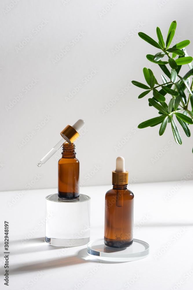 natural cosmetic skincare or essential oil bottles container and green leaf on white background. Hom