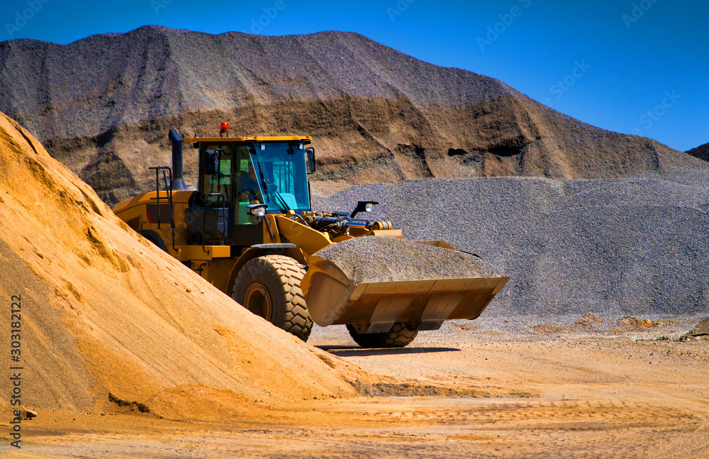 采砂场、挖掘设备、推土机，背景是一堆沙子。选择性聚焦。