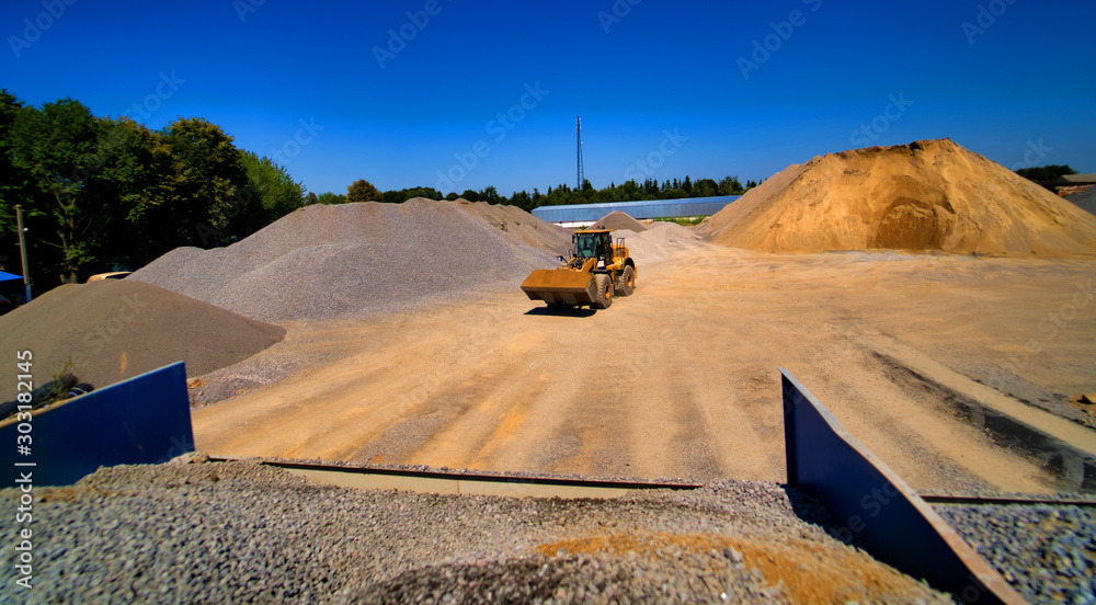 采砂场、挖掘设备、推土机，背景是一堆沙子和砾石。选择性f