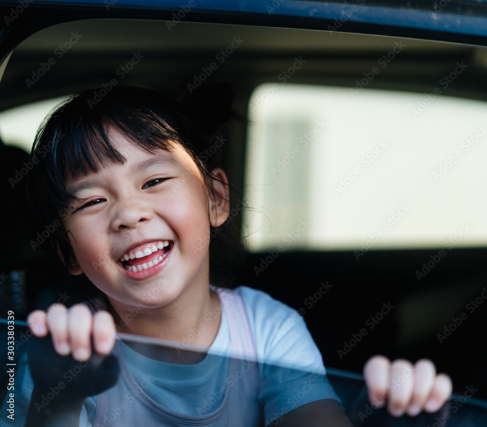 交通、安全、童年公路旅行和人的概念-快乐的小女孩坐在车里，孩子