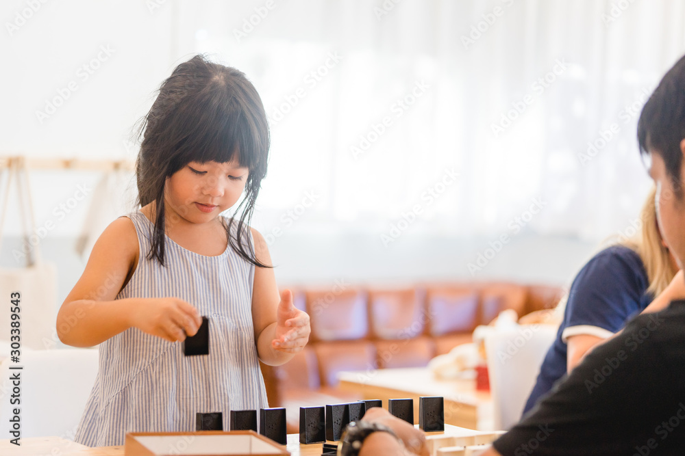 亲密时刻！父亲和他的亚洲小女孩在家玩。可爱的亚洲小女孩玩数学