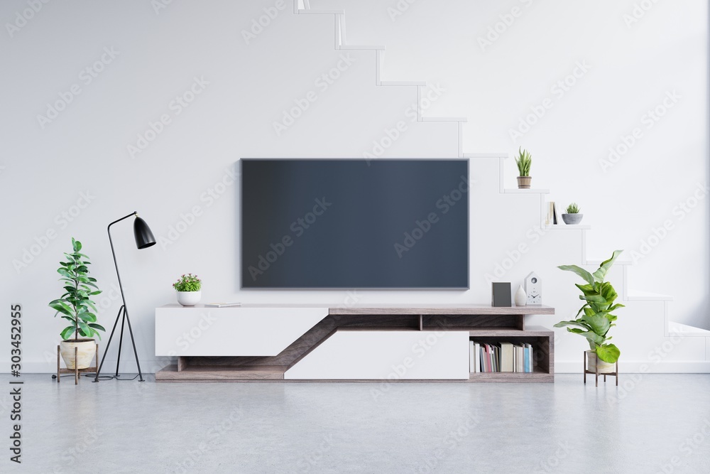 现代客厅橱柜上的电视，客厅里有植物，白色墙壁是空的。