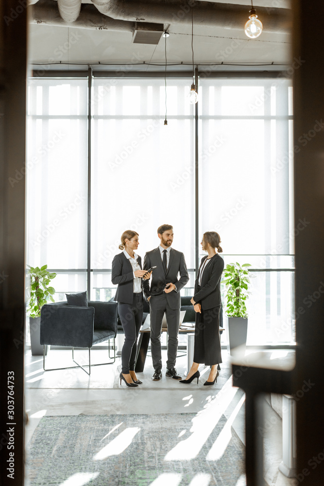 White-collar employees of financial institution having some business, standing and talking in the lu