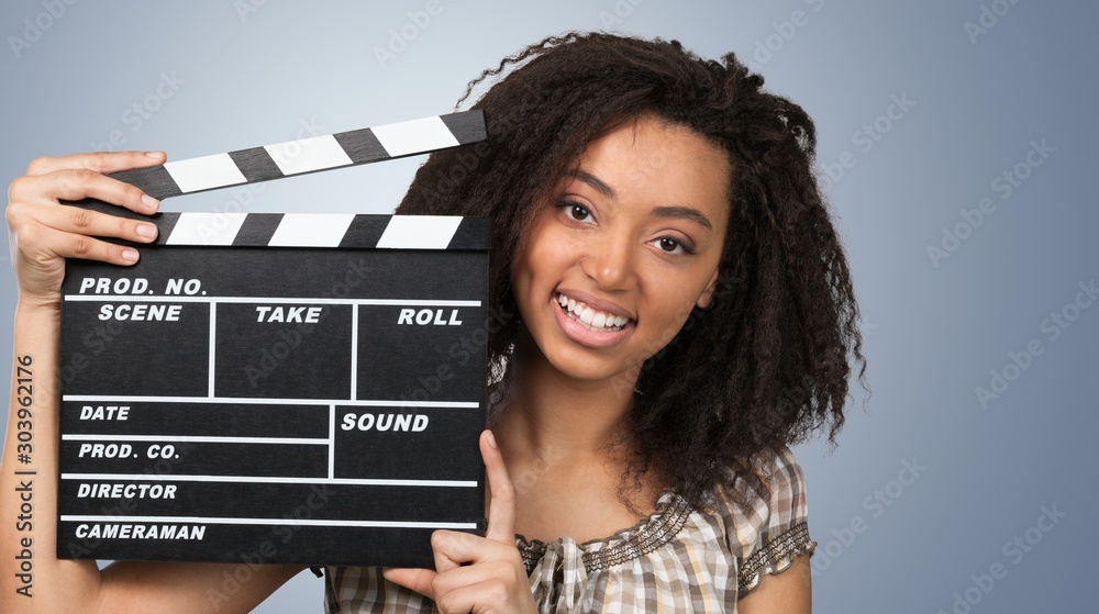 一个年轻的女人，拿着电影拍手，被隔离在白色