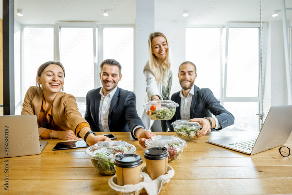 Portrait of a group of office workers taking business lunches in the office. Concept of healthy take
