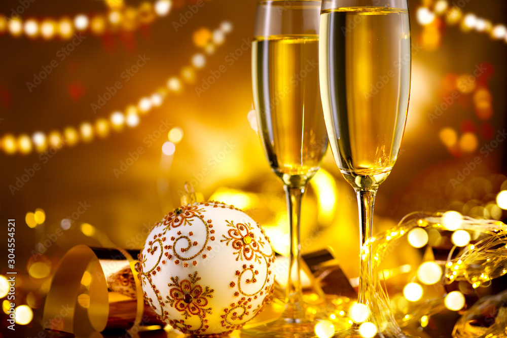 金色光晕背景下的节日香槟长笛。圣诞节和新年庆祝活动。两把长笛