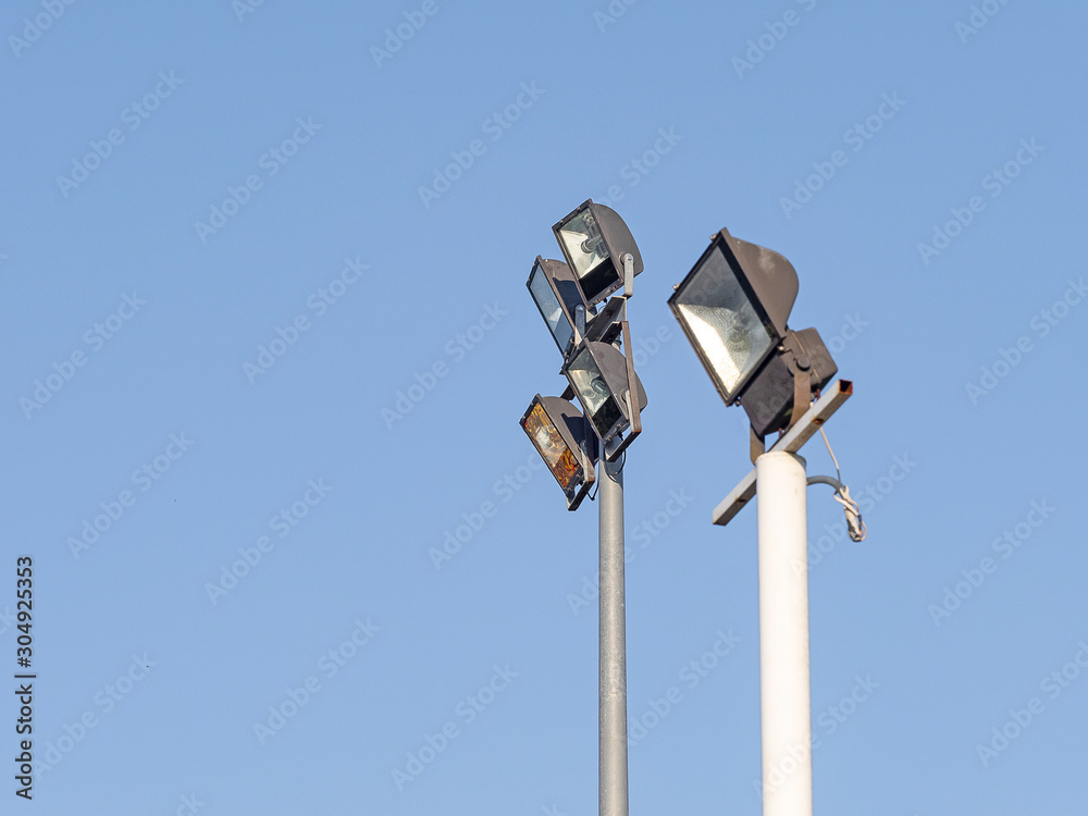 户外方形聚光灯，4件，用钢棒制成，杆上有蓝色的天空。