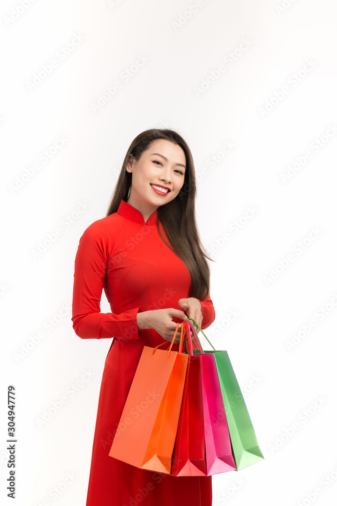 穿着传统奥黛服装、拿着购物袋的亚洲女性