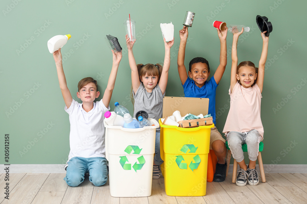儿童和靠近彩色墙的垃圾容器。回收的概念