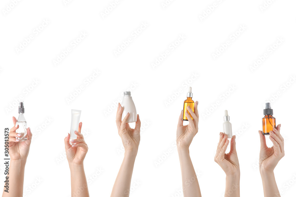 女性手拿不同的化妆品，装在白色背景的瓶子里