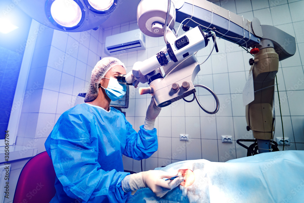 Eye surgery. A patient and surgeon in the operating room during ophthalmic surgery. Patient under su