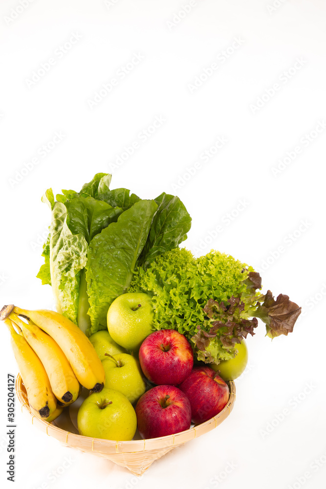 Bio-organic salad vegetables, apples, bananas in a basket. Good for health. Diet in the white backgr