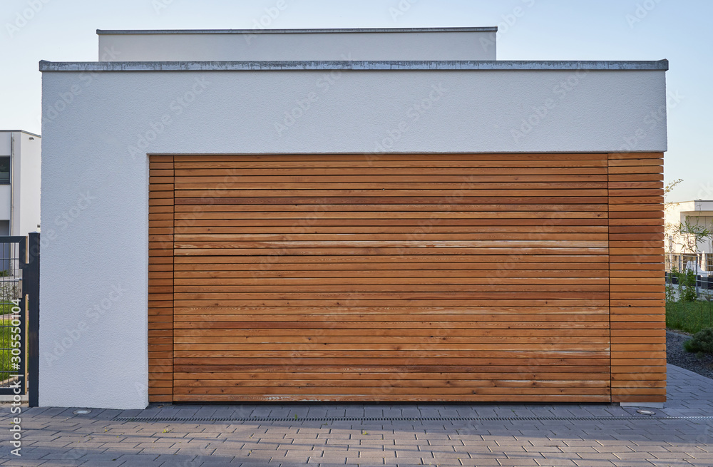 一个现代化的斯堪的纳维亚风格的车库，带木板车库门。带自动门的私人车库