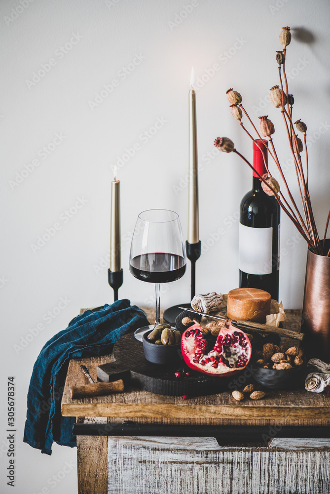 葡萄酒和小吃套装。一杯和一瓶红酒，配奶酪、石榴、杏仁和橄榄