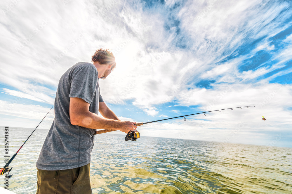 在美国佛罗里达州的大沼泽地钓鱼避暑旅行。游客从船上在海里钓鱼