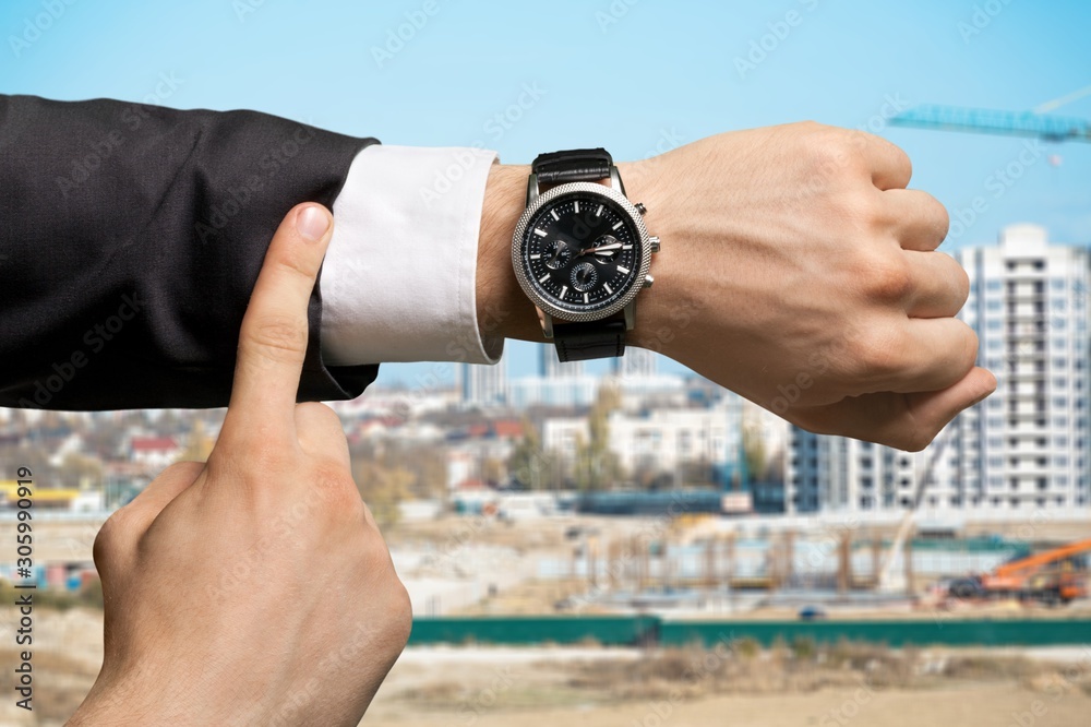 商人指着工地背景上的手表
