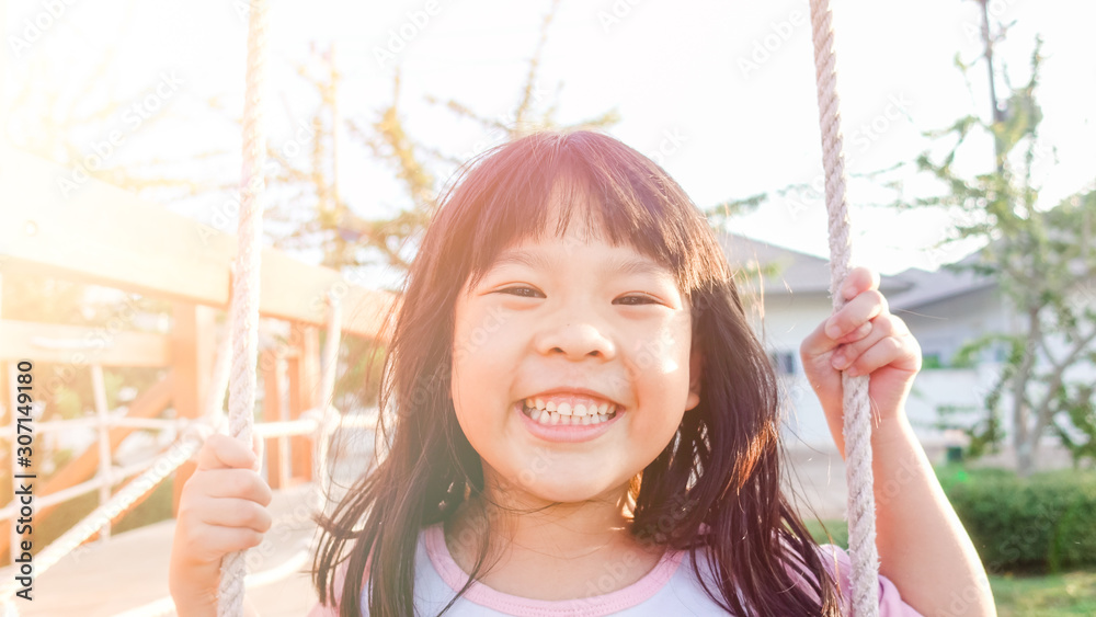5 years old.Asian child girl playing on playground in outdoor park.Happy Little asian girl playing s