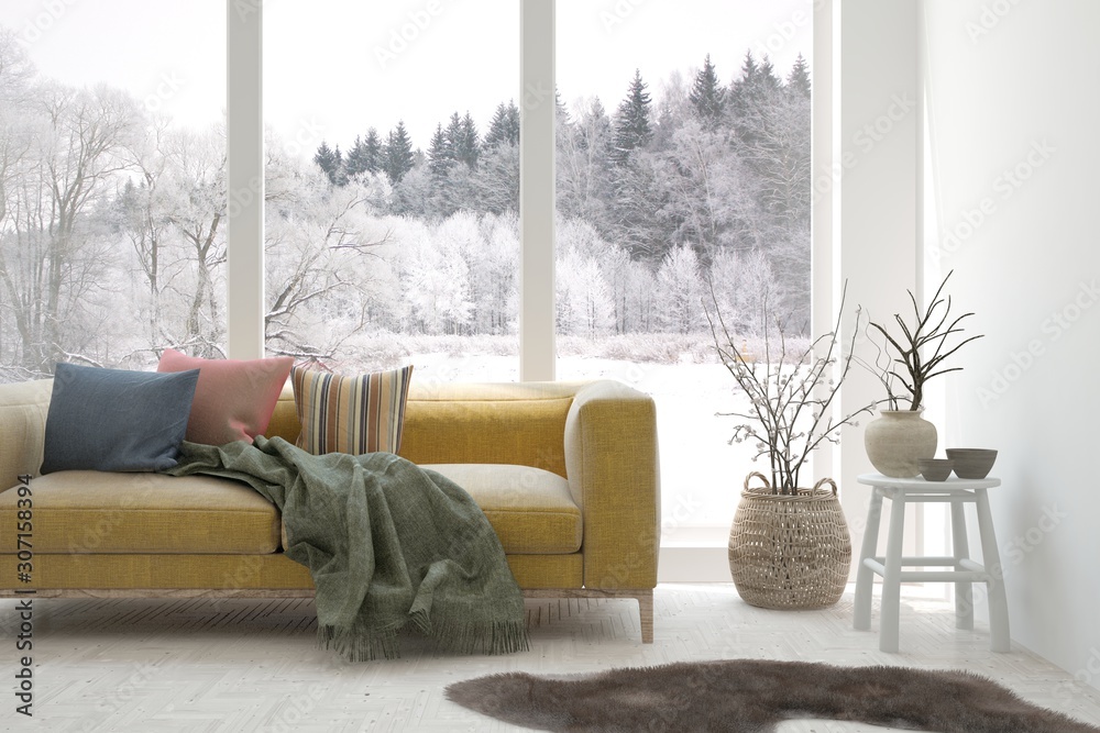 时尚的白色房间，窗户里有沙发和冬季景观。斯堪的纳维亚室内设计。