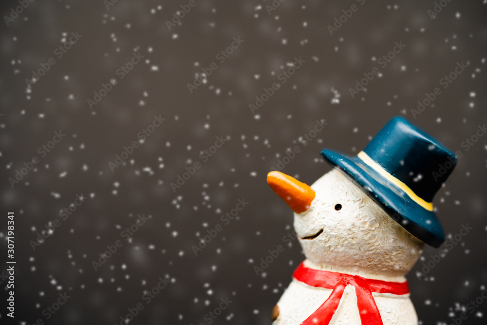 Happy smiley snowman wear blue hat and carrot nose standing with snowflakes in winter christmas seas