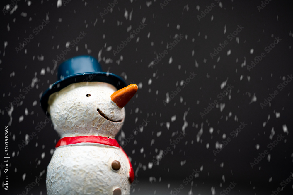 Happy smiley snowman wear blue hat and carrot nose standing with snowflakes in winter christmas seas