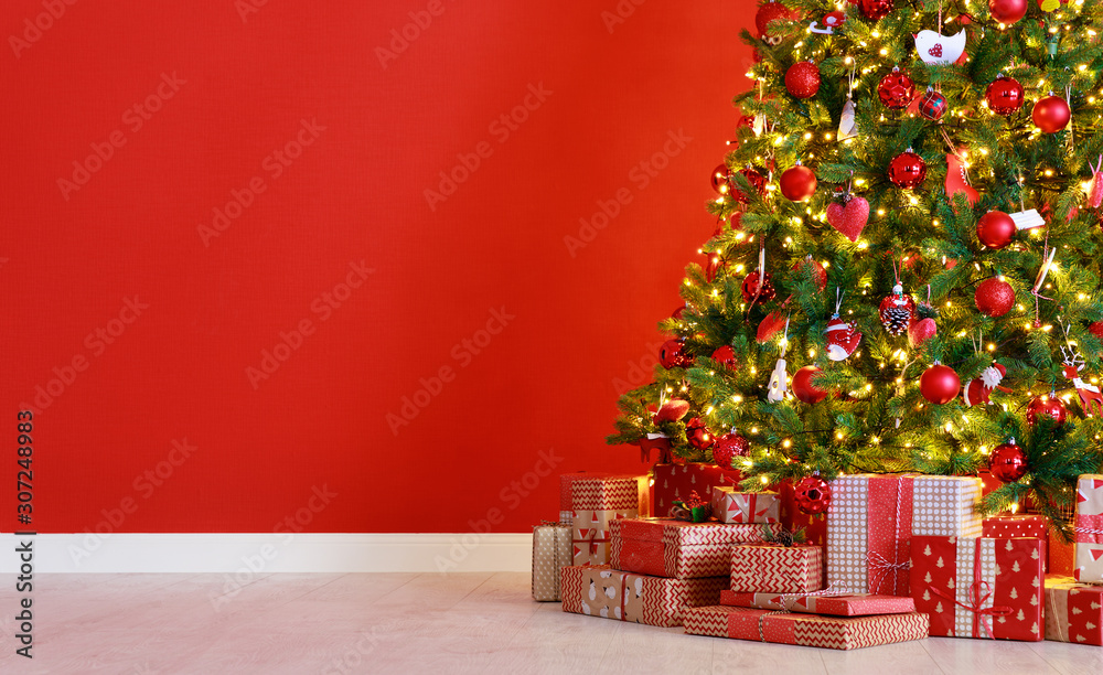 Christmas tree on the background of   red empty wall.