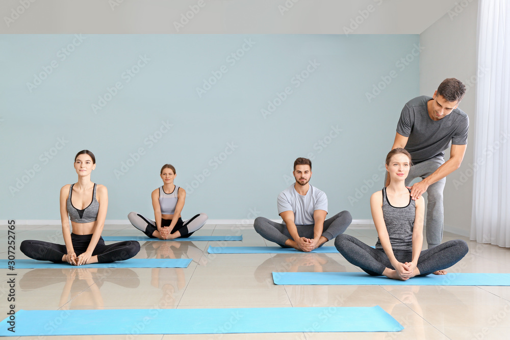 一群人在健身房与教练一起练习瑜伽