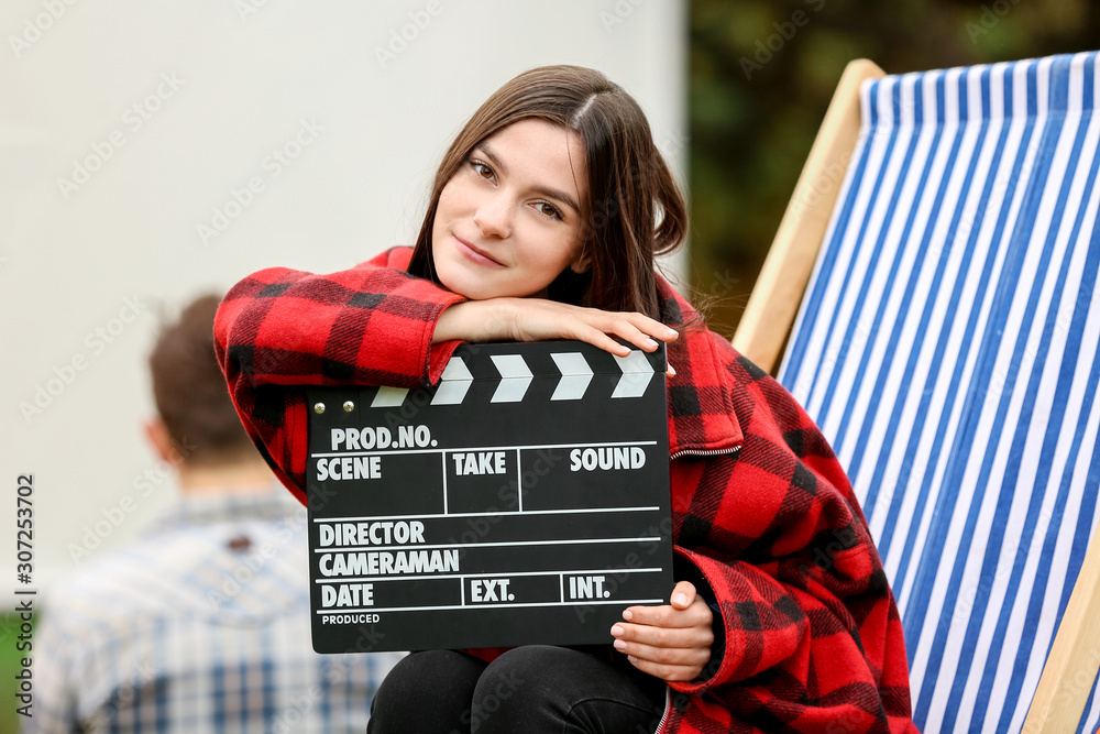 快乐的年轻女人在户外影院用电影拍手