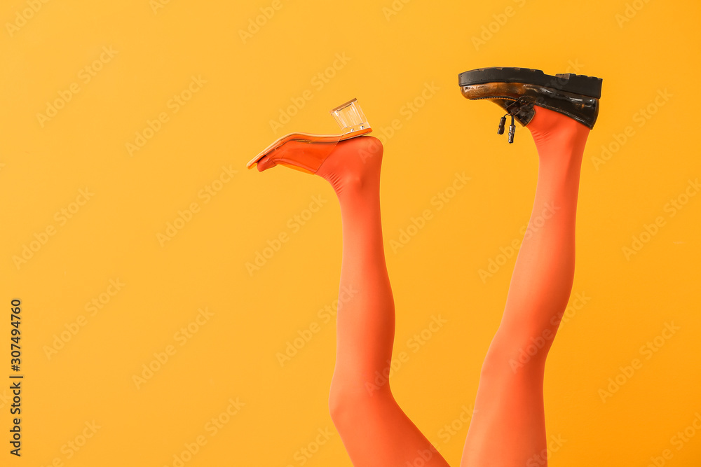 Young woman in different stylish shoes on color background