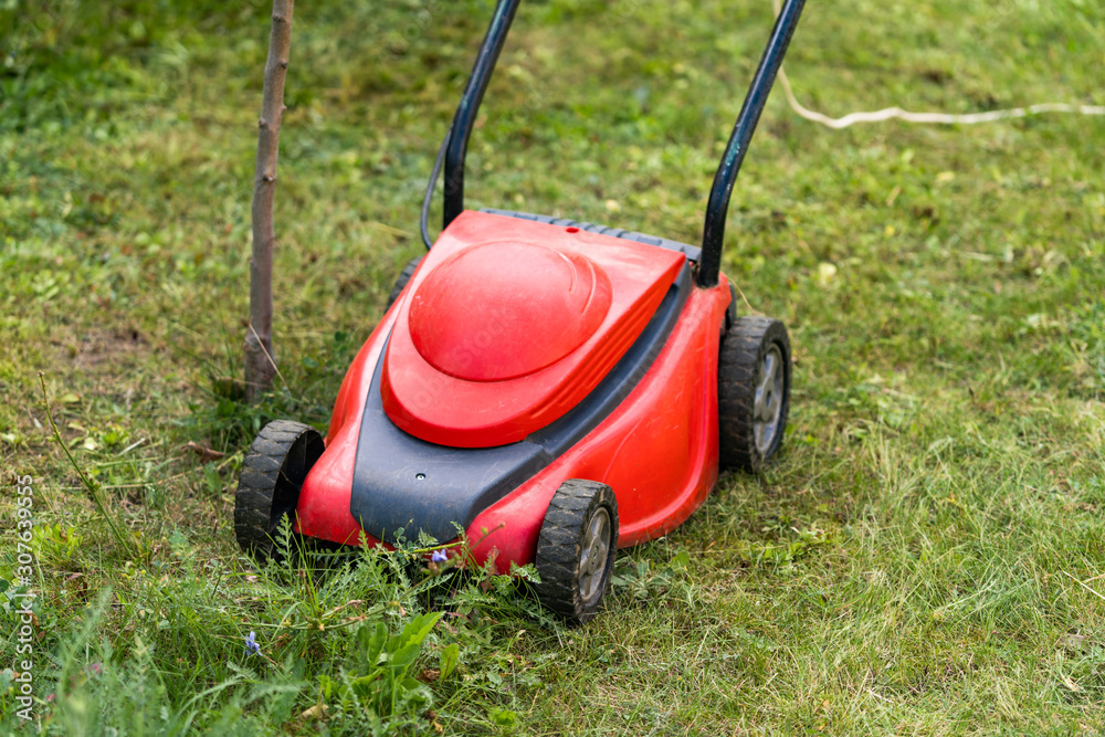 cutting grass machine, red lawn mower. Special equipment for landscape, terrain. Gardening concept. 