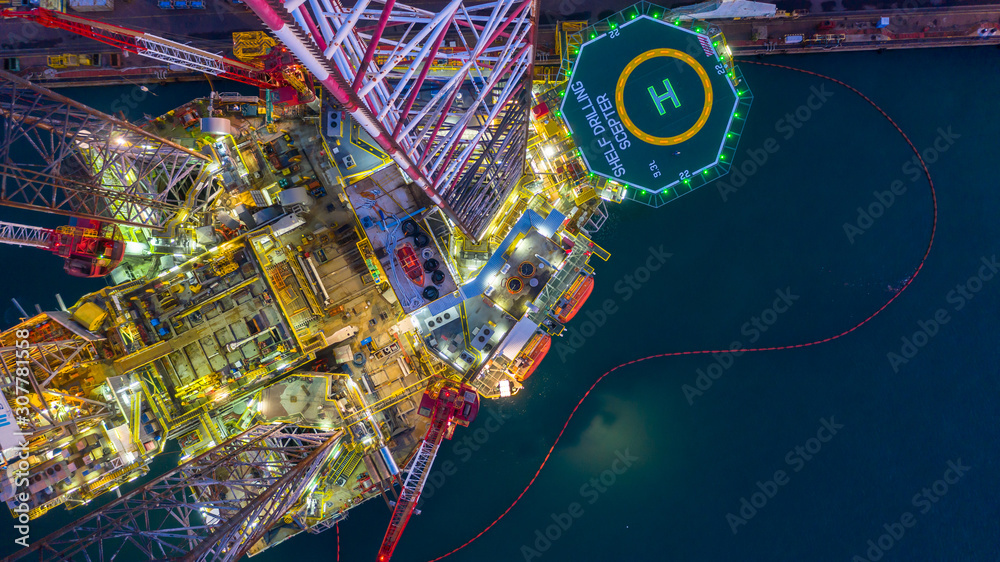 Aerial view construction offshore jack up rig drill at night, Offshore crane crude oil rig drilling 