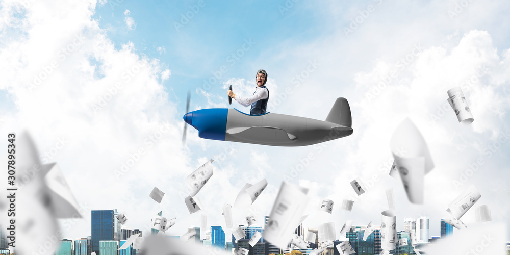 Businessman in aviator hat driving plane