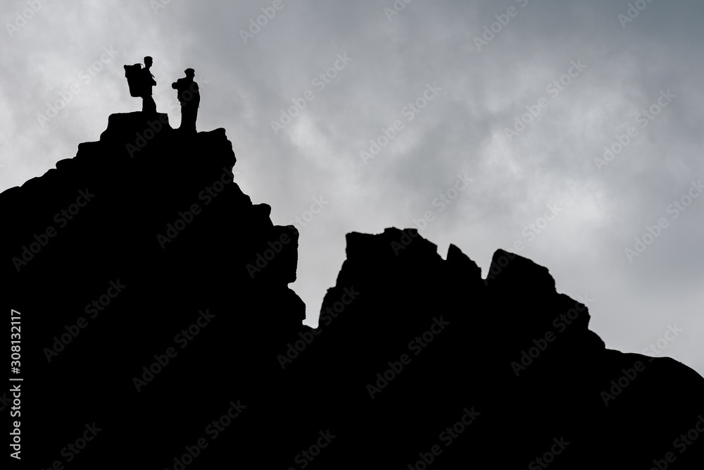 两个男人站在岩石上，指着远方。山地探险家拼贴画。双重曝光
