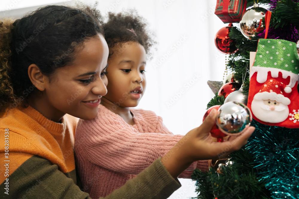 母女非裔美国女孩用装饰圣诞树，布置圣诞礼