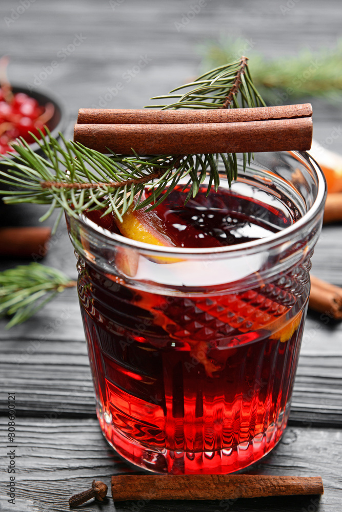 Glass of tasty mulled wine on wooden background
