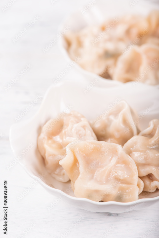 Fresh, delicious boiled pork gyoza dumplings, jiaozi on white background with soy sauce and chopstic
