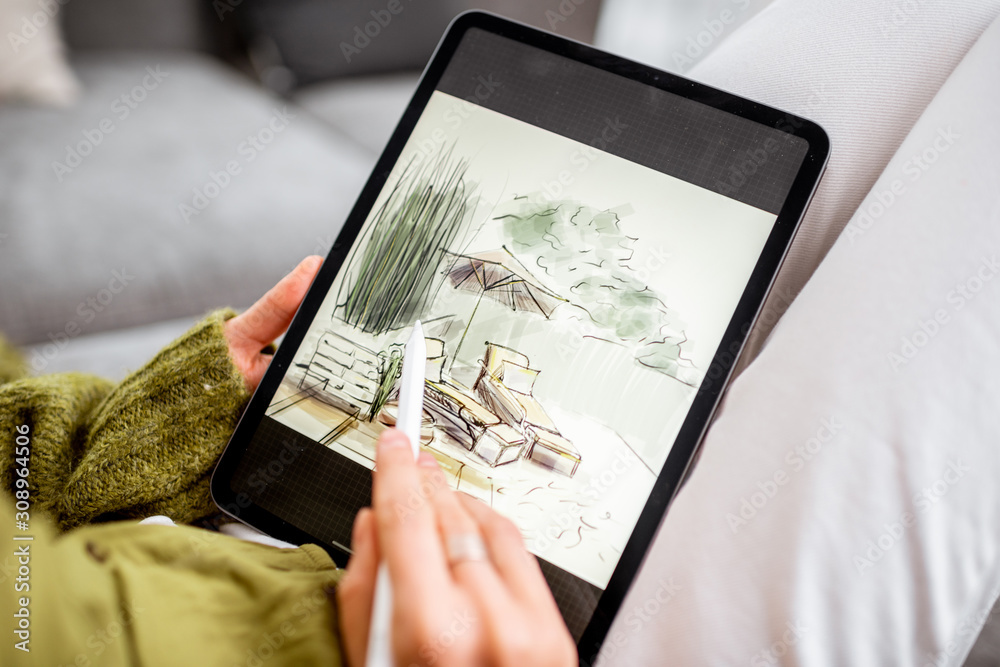 Artist or designer making landscape design, drawing on a digital tablet with pencil, close-up on a s