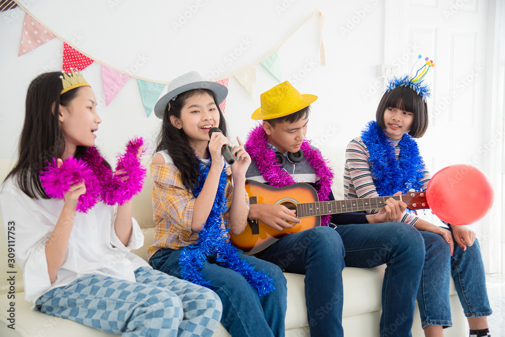 Group of Happy Asian teenager sing a song and playing guitar with friends in Party.
