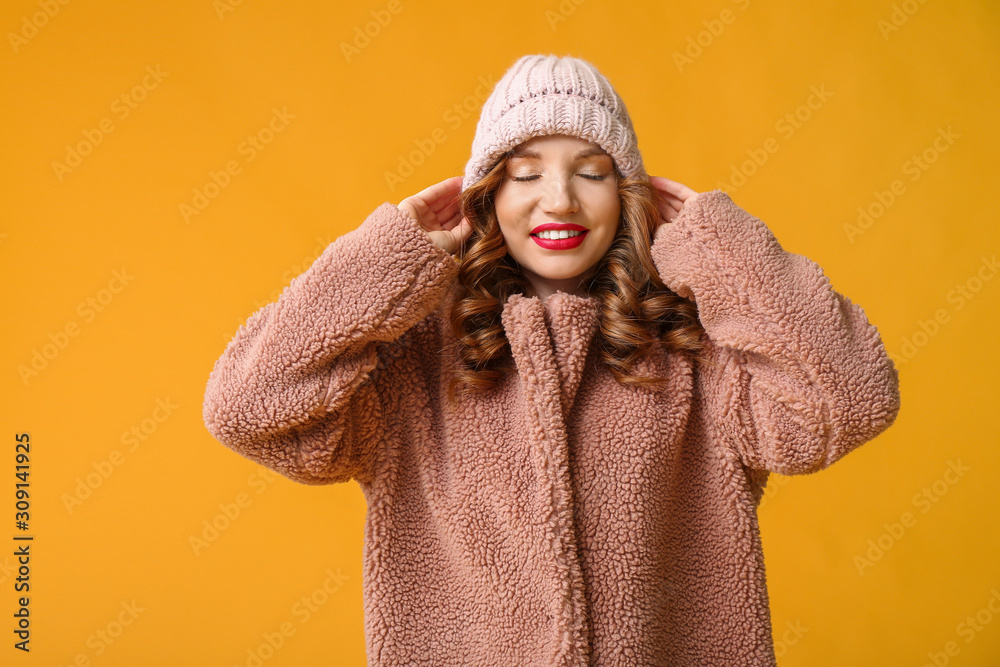 穿着彩色背景冬装的快乐年轻女人
