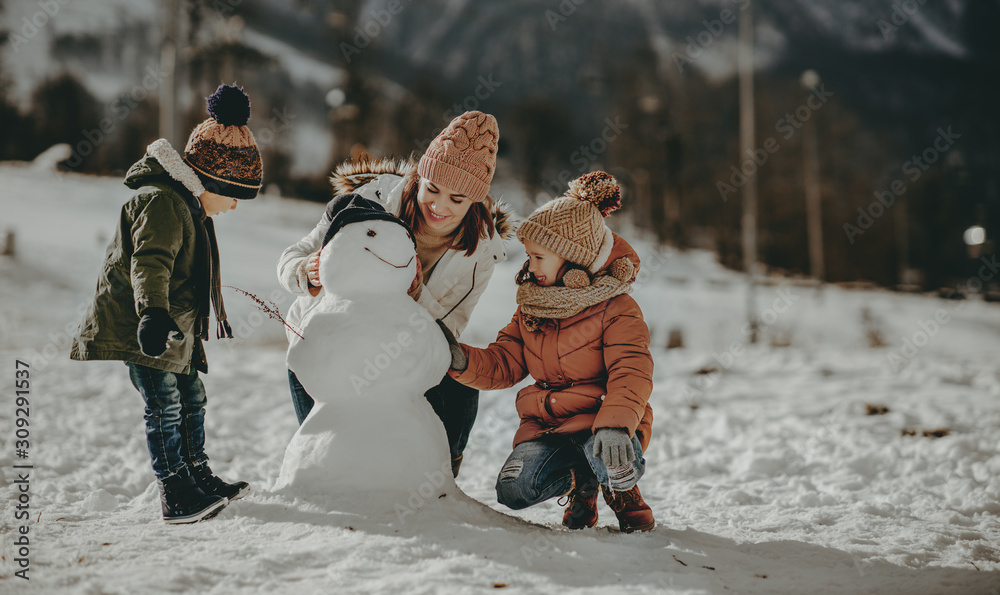 快乐的家庭母亲和孩子们在冬季散步时玩得很开心。