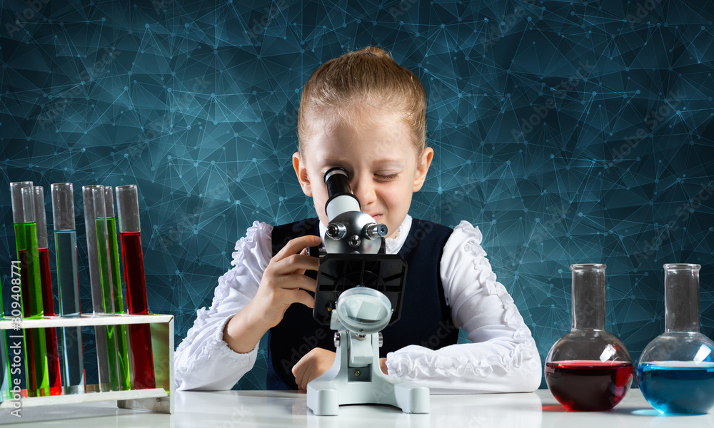 Little girl scientist looking through microscope