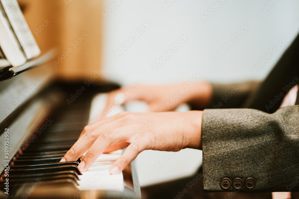 男人在教堂里用三角钢琴做礼拜。男钢琴家演奏经典钢琴。专业音乐