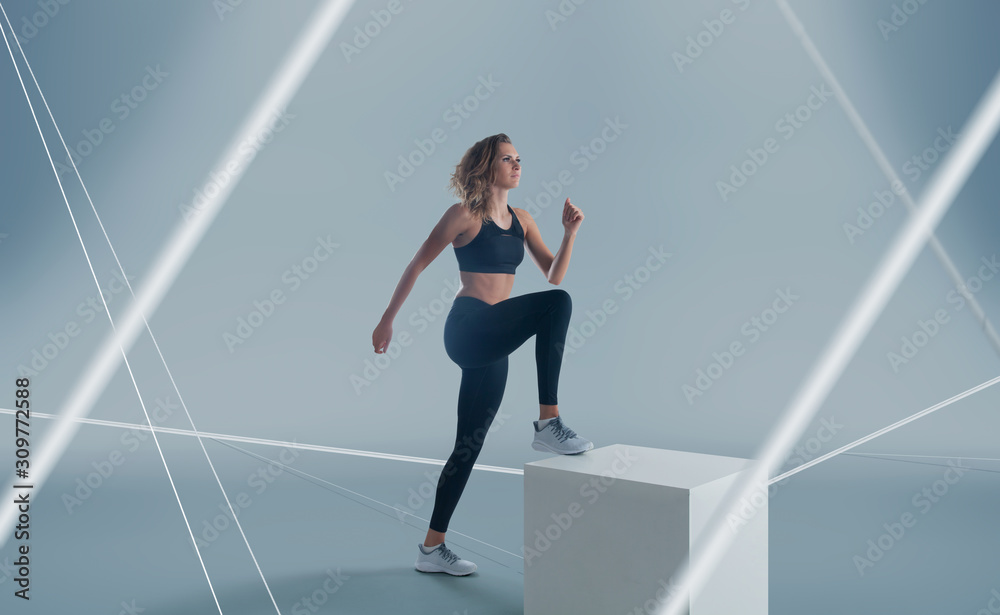 Female athlete running and jumping. Side view shot of healthy woman working out against hi tech back