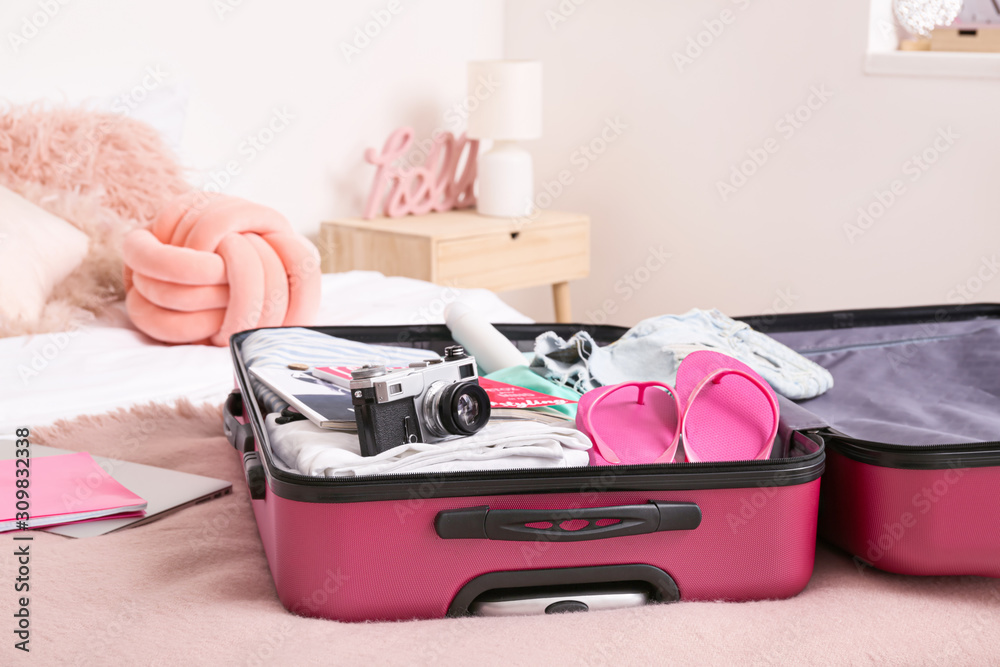 打开行李箱，床上放着打包好的衣服和配件