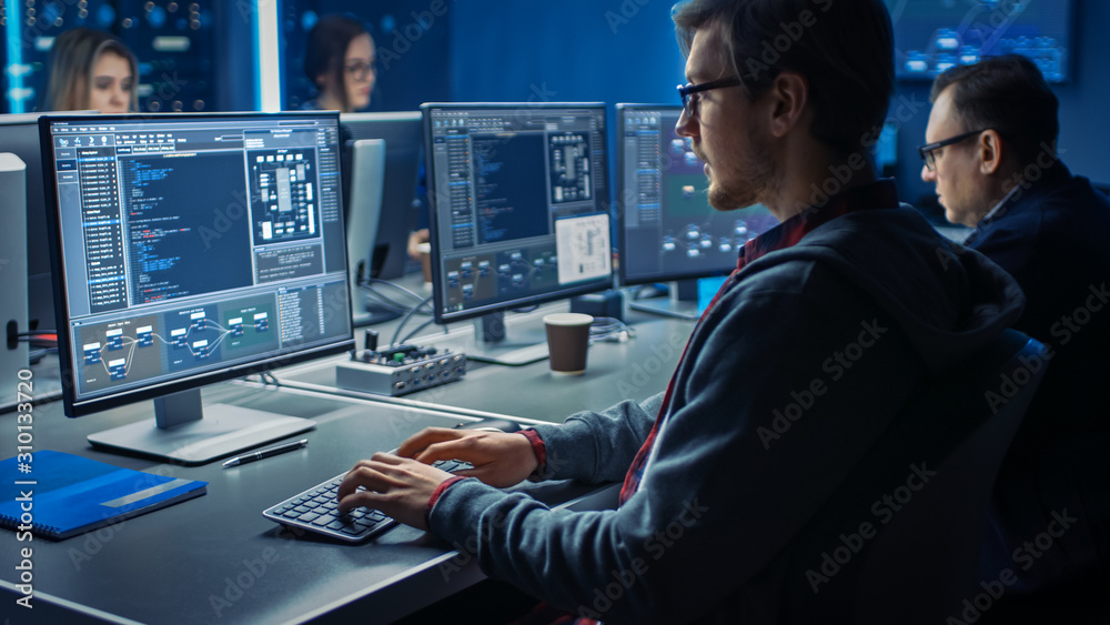 智能男性IT程序员在数据中心系统控制中的桌面绿色实体屏幕计算机上工作