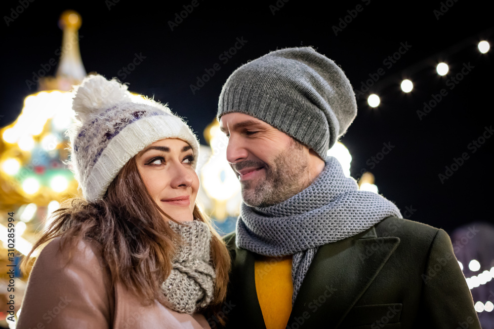 Portrait of a loving couple among Christmas street decorations during winter holidays