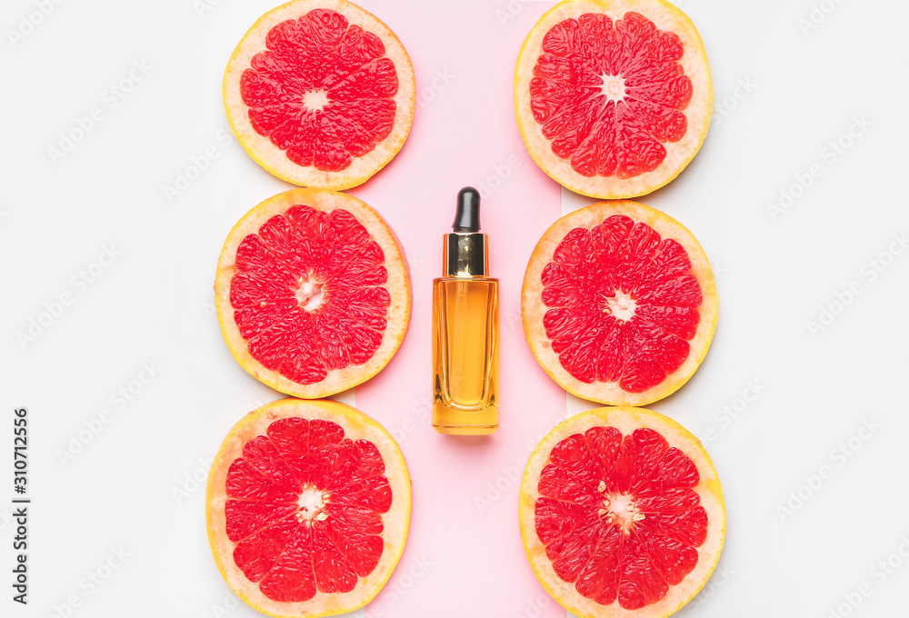 一瓶精油和葡萄柚片，颜色背景
